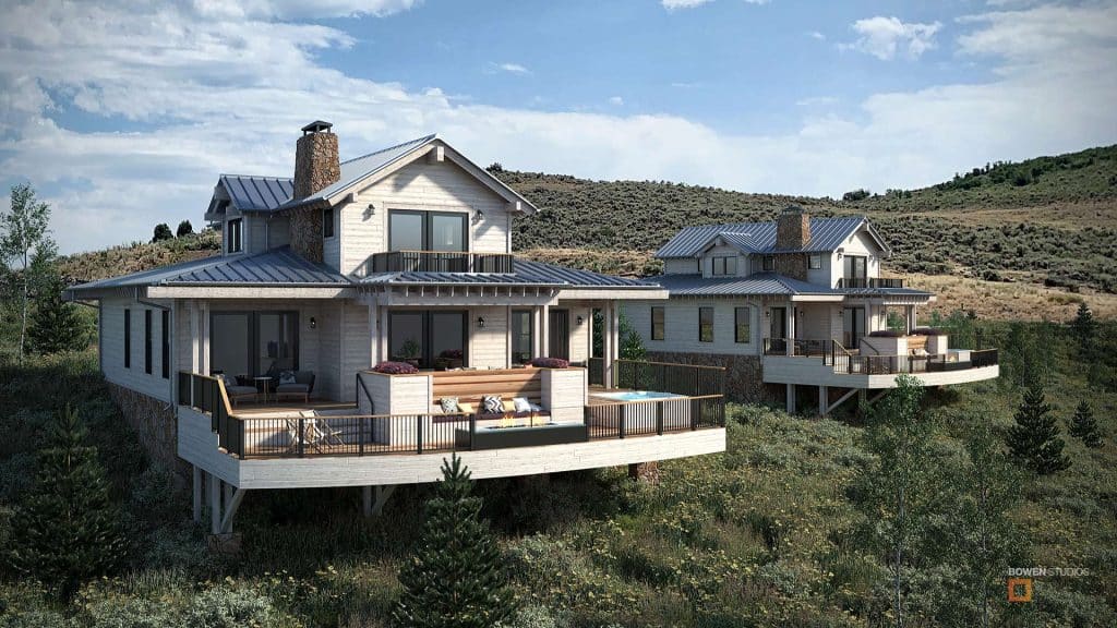 Two new homes with suspended deck on a mountain side, with blue skies and puffy white clouds in the background.